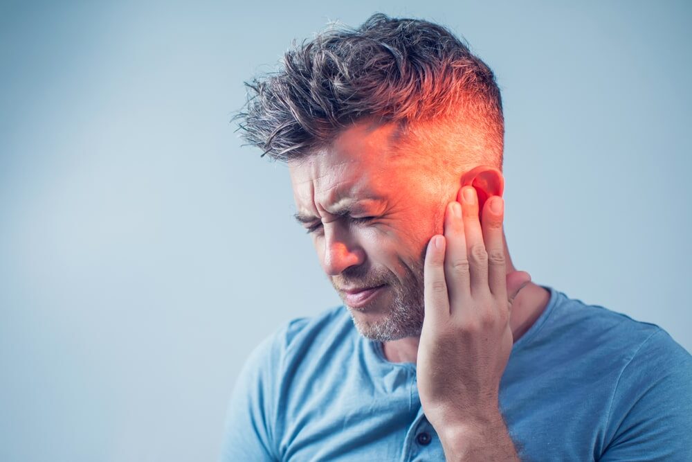 Man with earache is holding his aching ear body pain concept